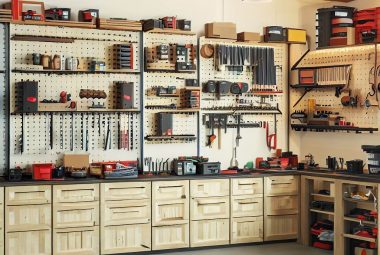An image of a well-organized garage with various storage solutions. The scene shows wall-mounted shelves built from 2x4's, ceiling storage, pegboards with tools hanging, cabinets, and a workbench. Each storage area is visibly marked and neatly arranged, depicting an ideal garage storage setup.