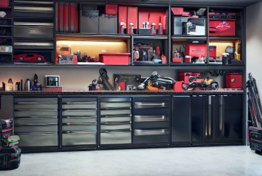 An image of a clean and organized garage with Husky garage cabinets and shelving with neatly stacked household items and tools.