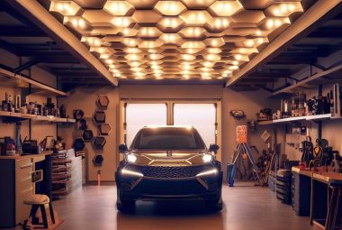 An image showing a beautifully lit garage with hexagon lights installed on the ceiling, creating a visually pleasing pattern. The garage is well-organized, with various tools neatly placed on the shelves and a car parked inside. The bright, efficient light from the hexagon fixtures highlights the garage's features, creating a warm and inviting atmosphere.